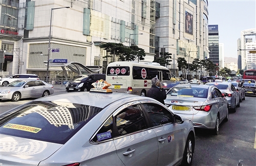 韩国首尔街头有大量出租车在后车窗处贴有反对kakao拼车服务的统一标语。 本报记者 白云飞摄