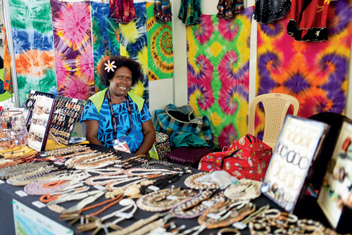 莫尔兹比港的商贩在等待顾客光临，他们售卖着当地传统纹饰布料、首饰或纪念品。