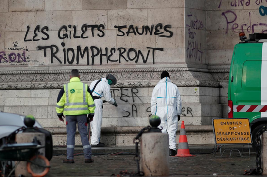 2018年12月2日，法国巴黎，工作人员清理抗议者在凯旋门留下的涂鸦，上面写着“黄背心将凯旋”的字样。REUTERS/Benoit Tessier